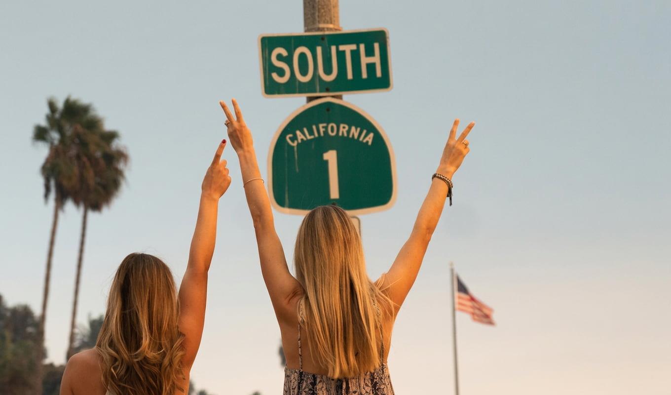 Women throwing peace sign to the California 1 sign