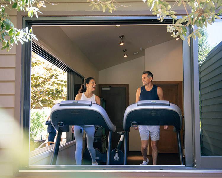 A couple using the treadmills in fitness center.