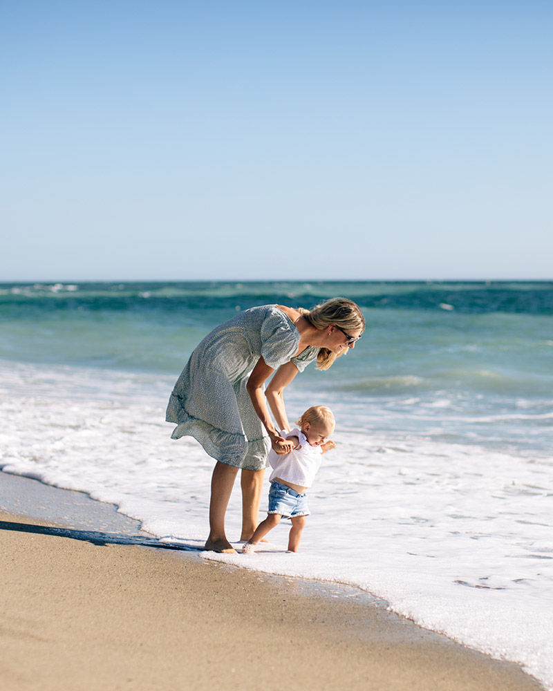 Mother and baby playing in the ocean. 