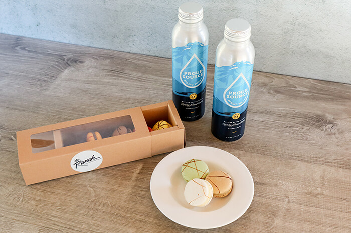 a plate of macarons and two water bottles