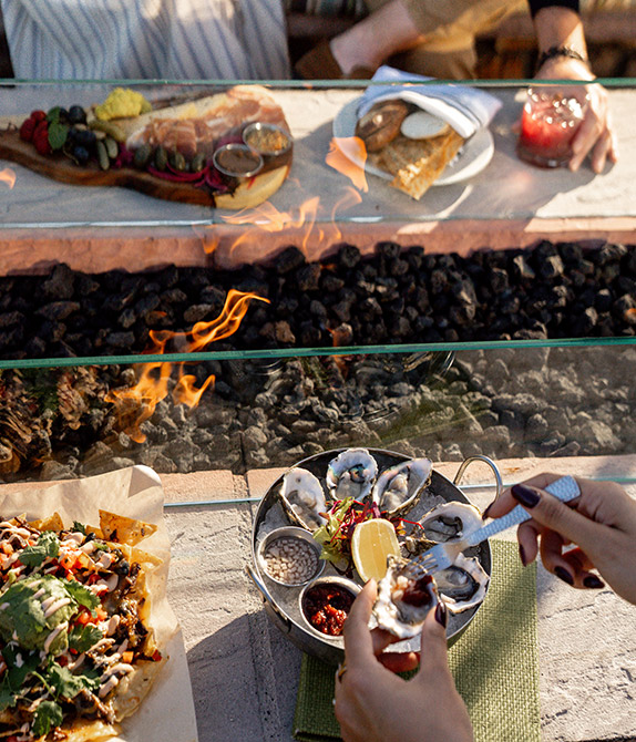 Outdoor oysters, and nachos being eaten by the fire pit.